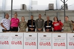 U.S. Airmen with the 156th Wing, Puerto Rico Air National Guard, U.S. Marines assigned to Det. 1 Landing Support Company, Combat Logistics Regiment 45, 4th Marine Logistics Group, and faculty members pose for a photo during a toy distribution at Dr. Julio Henna Elementary School, San Juan, Puerto Rico, Dec. 14, 2023. The event was part of the Toys for Tots program.