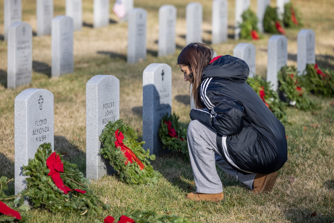 Lauren Forgas, native of Stafford, Virginia, says a prayer during the annual Wreaths Across America wreath-laying ceremony at the National Cemetery at Quantico, Triangle, Virginia, Dec. 16, 2023. The event was held in unity with other cemeteries nationwide to remember and honor those who paid the ultimate sacrifice, but also to teach generations about those who have and currently serve. (U.S. Marine Corps photo by Lance Cpl. Ethan Miller)
