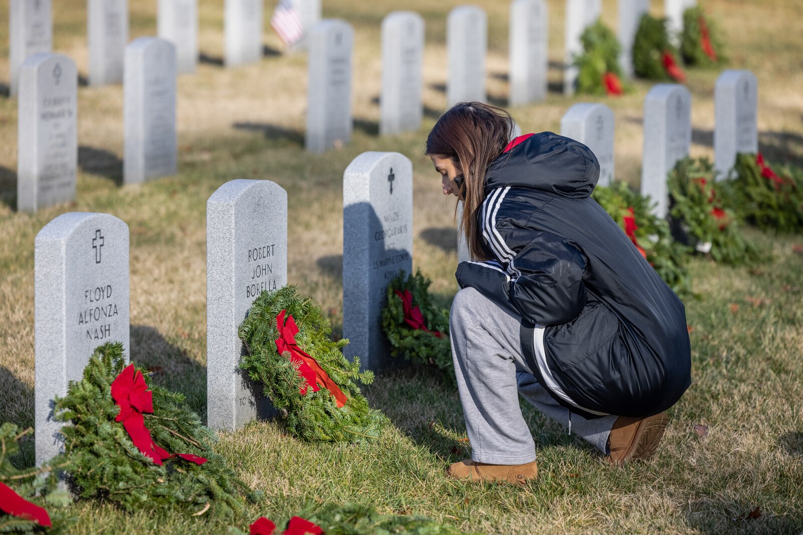 Lauren Forgas, native of Stafford, Virginia, says a prayer during the annual Wreaths Across America wreath-laying ceremony at the National Cemetery at Quantico, Triangle, Virginia, Dec. 16, 2023. The event was held in unity with other cemeteries nationwide to remember and honor those who paid the ultimate sacrifice, but also to teach generations about those who have and currently serve. (U.S. Marine Corps photo by Lance Cpl. Ethan Miller)