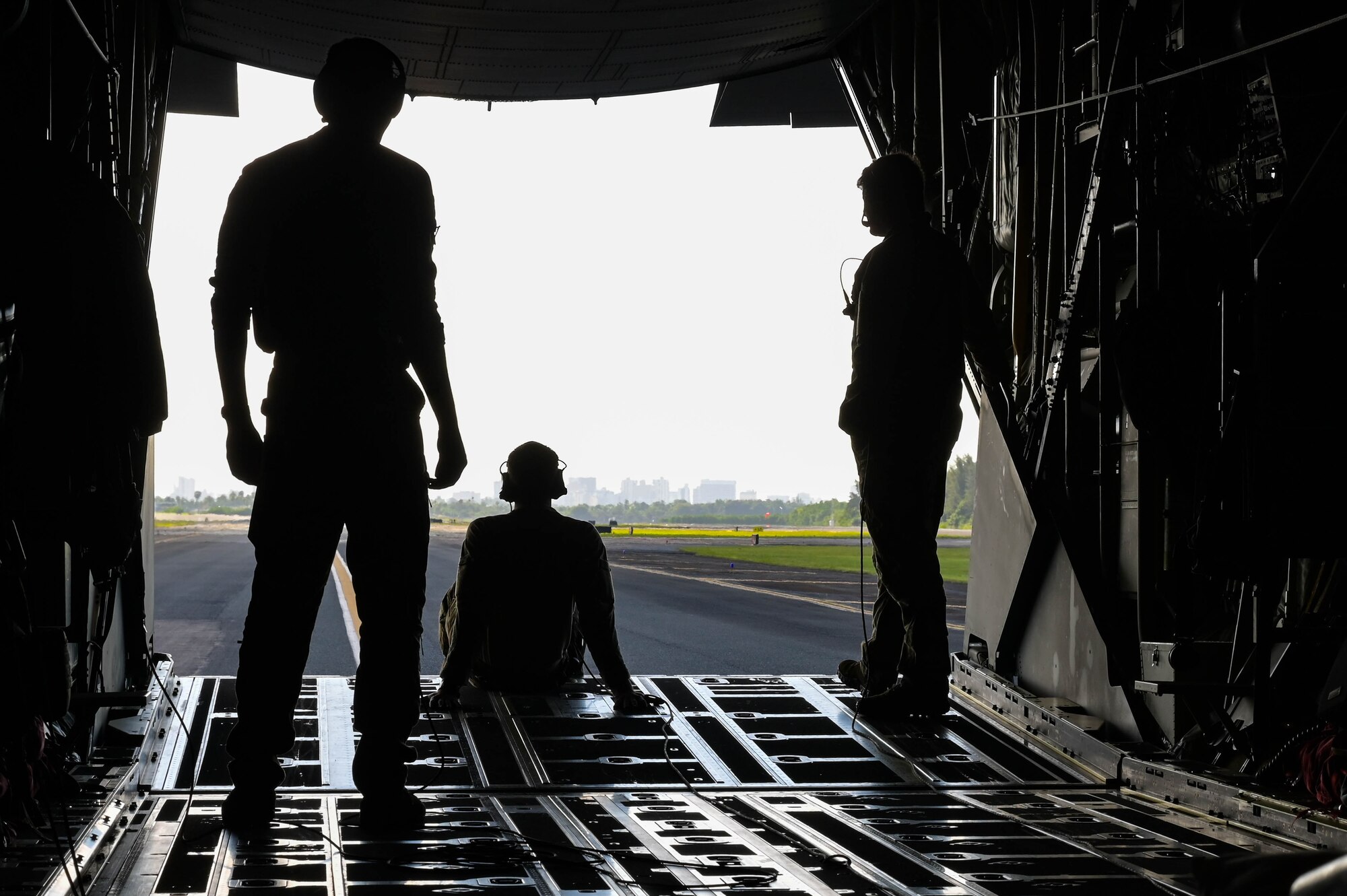 U.S. Air Force Air Commandos look out the back of an MC-130J Commando II after landing in Puerto Rico to refuel, Dec. 7, 2023.