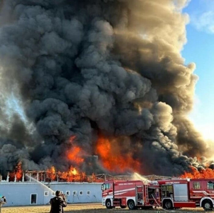 Firefighters spray water onto a warehouse fire.