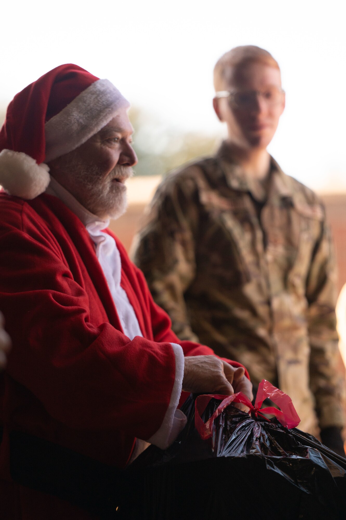 Santa helps load gifts into a Humvee.