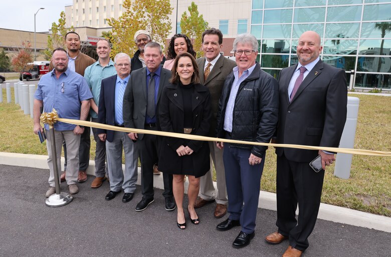 George Condoyannis, U.S. Army Corps of Engineers, Mobile District, Construction Division chief (center second row) poses with members of his team in front of the new James A. Haley Veteran’s Administration Bed Tower in Tampa, Florida, Jan. 21, 2023. The $148.6 million bed tower took five years to build and adds 245,000 square feet of new space and another 5,000 square feet of renovated space to the hospital.