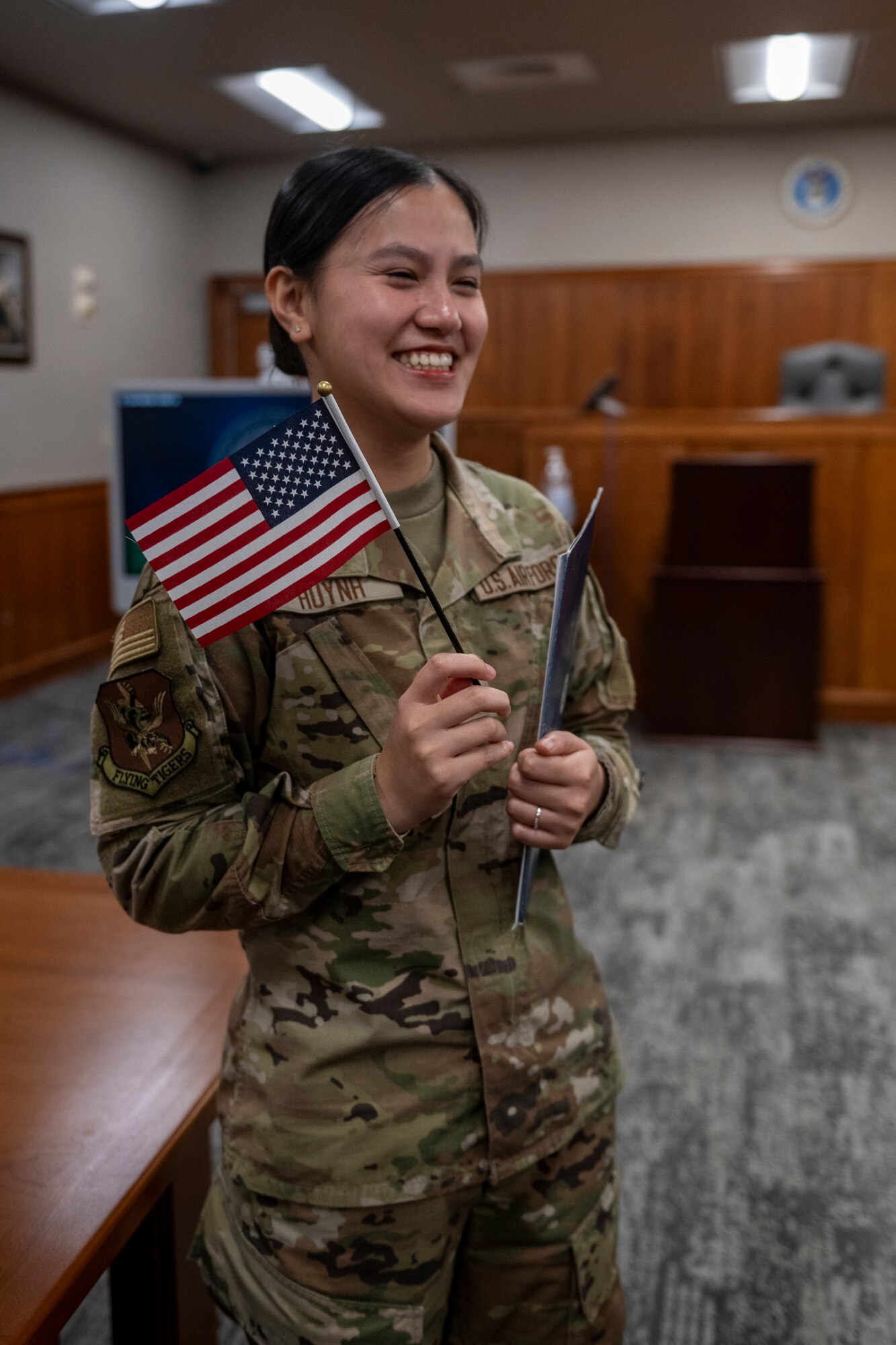 U.S. Air Force Airman 1st Class Thi Huynh, 23rd Wing religious affairs Airman, holds an American Flag and her Certificate of Naturalization