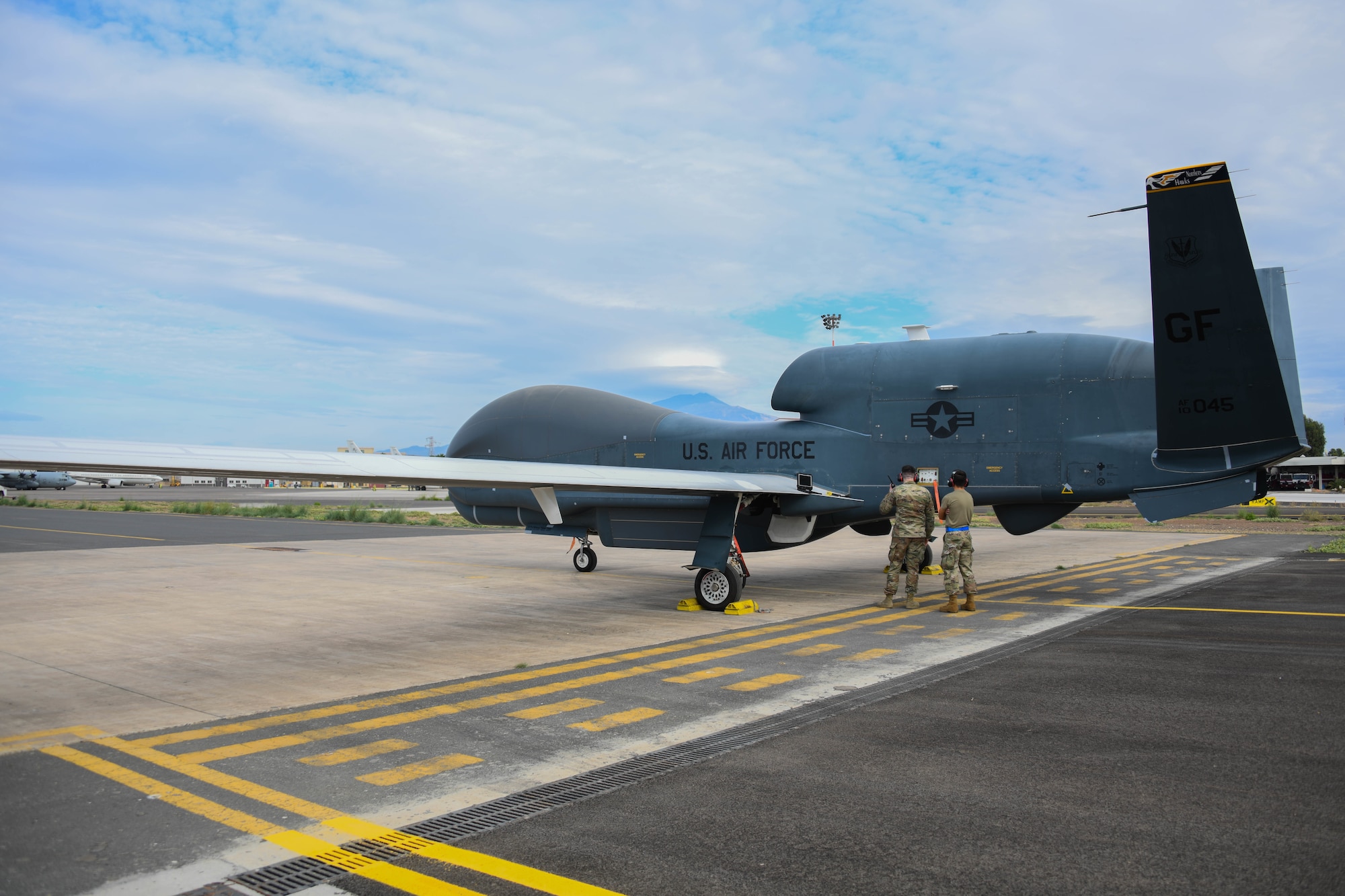 An aircraft sits parked on a runway.