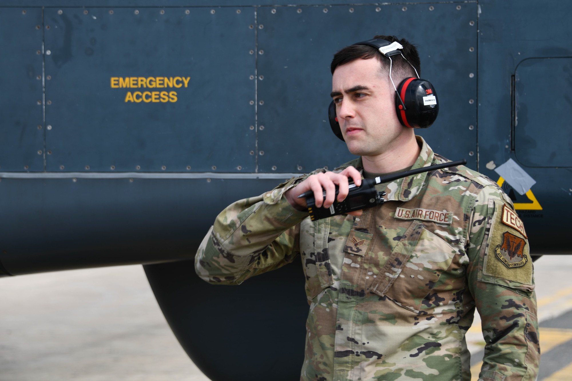Military member with radio and ear protection.