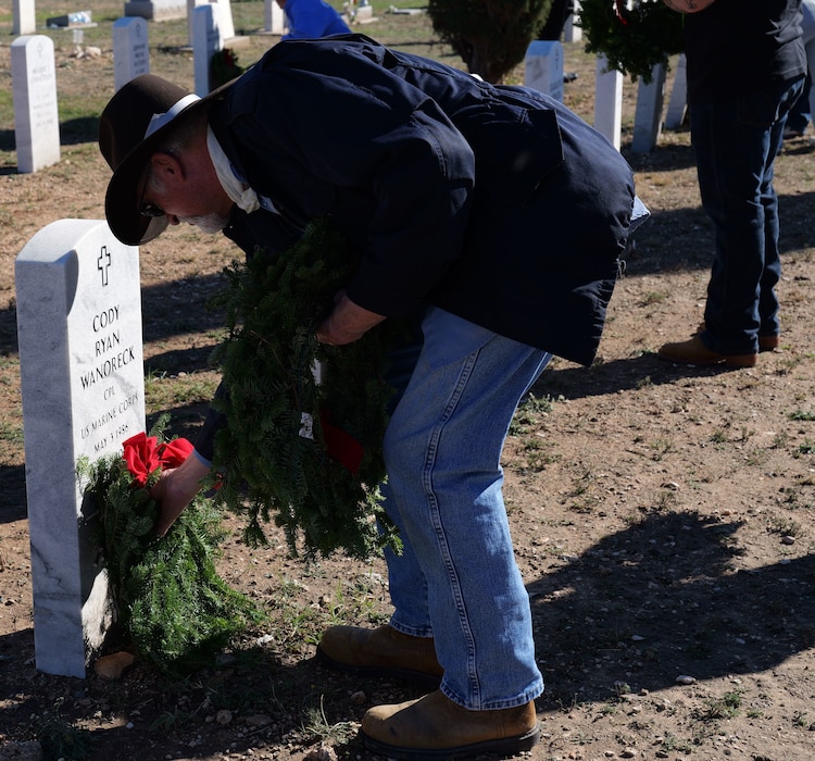 A member of the San Angelo Community places a wreath after the Wreaths Across America ceremony at San Angelo, Texas, Dec. 16, 2023. Following the ceremony, over 300 wreaths were placed at the headstones of deceased military members. (U.S. Air Force photo by Staff Sgt. Nathan Call)