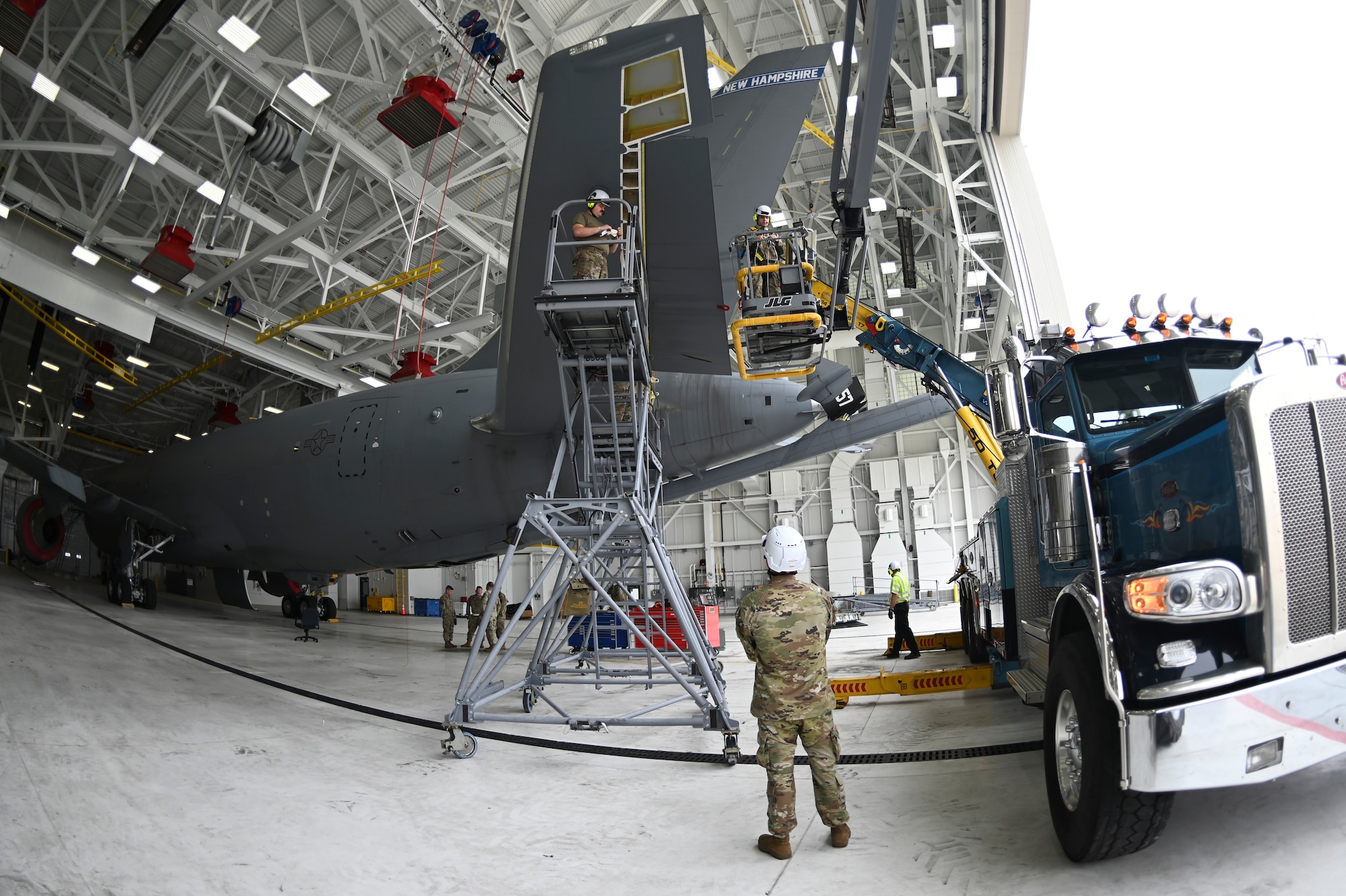 Airmen stand on lift in front of aircraft