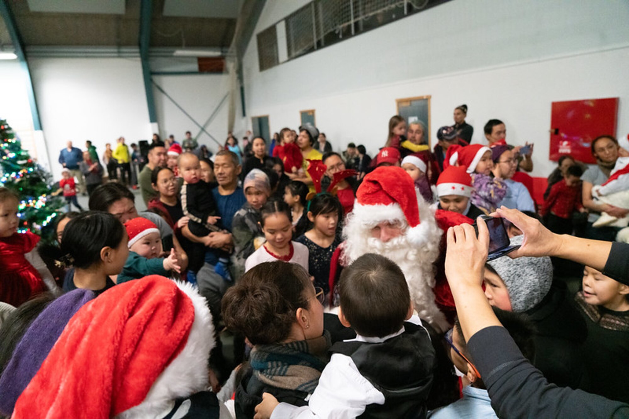 Santa is surrounded by a mass of people for a celebration