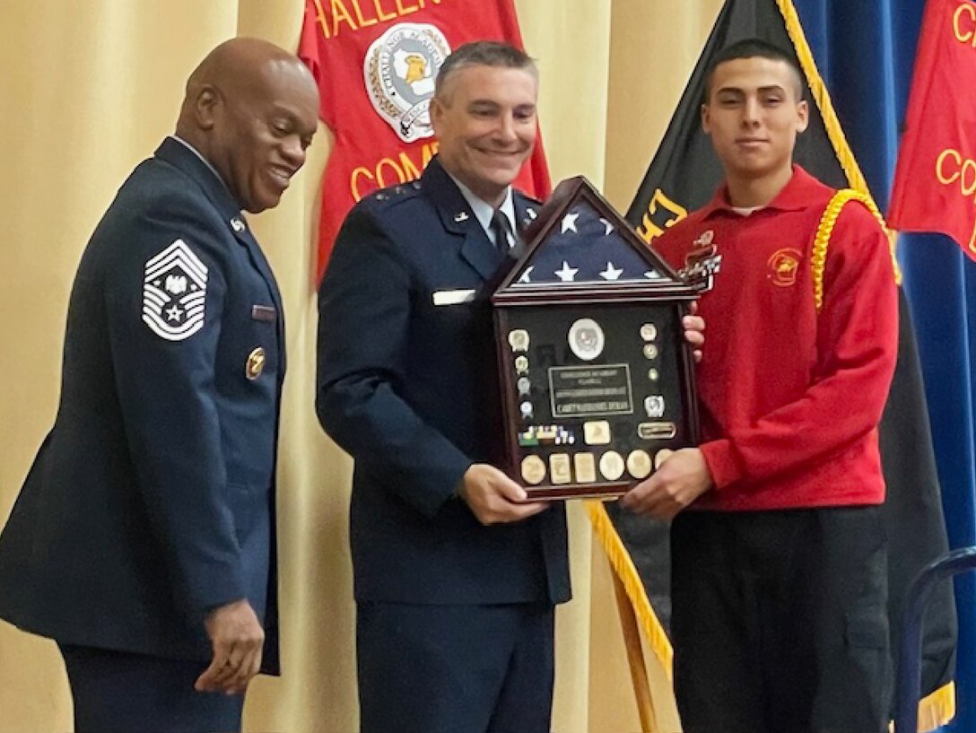 Chief Master Sgt. of the National Guard Tony Whitehead, senior enlisted advisor to the Chief of the National Guard Bureau, and Maj. Gen. Paul Knapp, Wisconsin’s adjutant general, present the Distinguished Honor Graduate trophy to Nathaniel Duran of Beloit, Wis., during a graduation ceremony Dec. 16 for 98 cadets from 33 Wisconsin counties at Baraboo High School in Baraboo, Wis. Challenge Academy reshapes the lives of 16-to-18-year-olds at risk of not graduating from high school. It uses a structured, military-style environment and state-certified teachers and counselors to build Cadets’ academic abilities, character, self-confidence, and personal discipline. Wisconsin Department of Military Affairs photo by Thomas Beckman