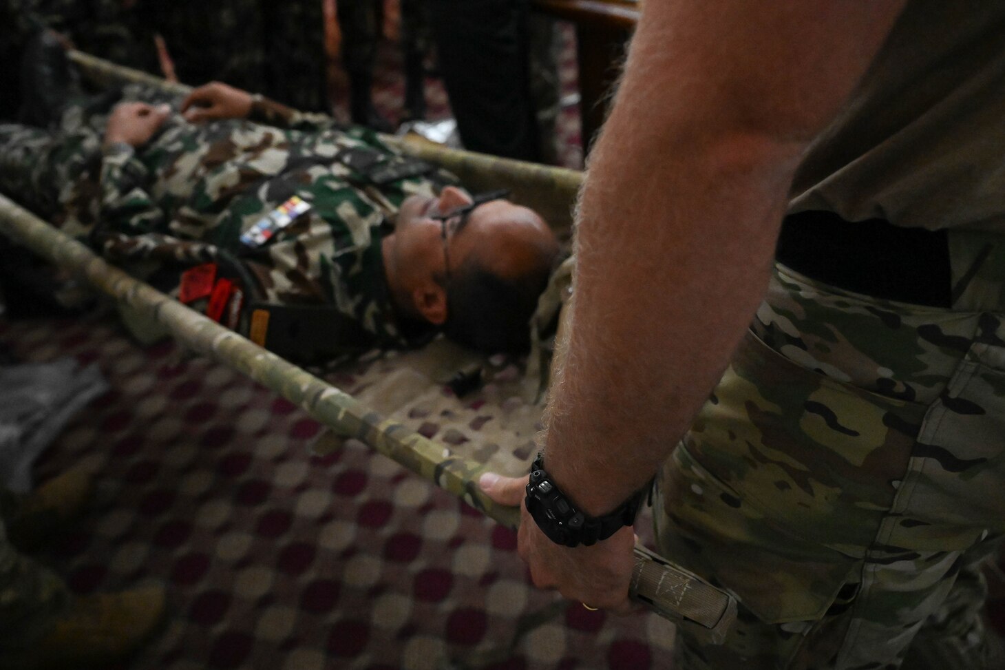 A U.S. Naval special warfare operator demonstrates casualty litter evacuation procedures with members of the Nepali Army and Nepali Special Operations Force (SOF) Brigade during a subject matter expert exchange at Ganesh Kashya, the Nepali Army headquarters in Kathmandu, Nepal. Naval Special Warfare trains with forces worldwide to improve and further specialize skills required to conduct missions and respond to crises.