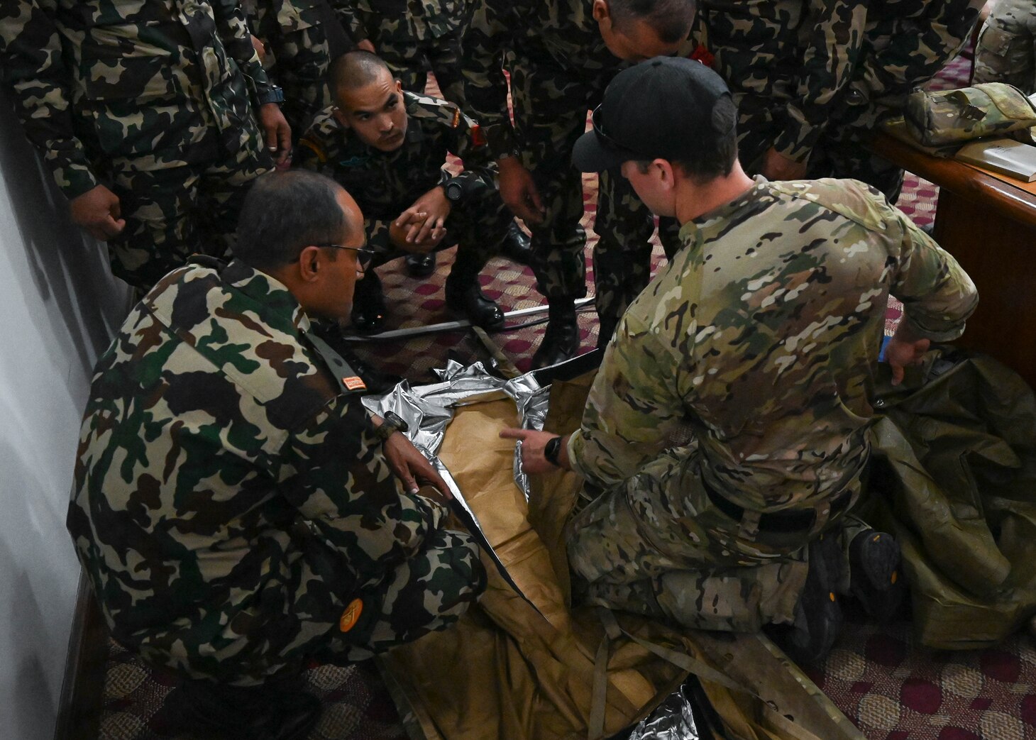 A U.S. Naval Special Warfare operator demonstrates the use of warming blankets as used in tactical combat casualty care with members of the Nepali Army and Nepali Special Operations Force (SOF) Brigade during a subject matter expert exchange at Ganesh Kashya, the Nepali Army headquarters in Kathmandu, Nepal.