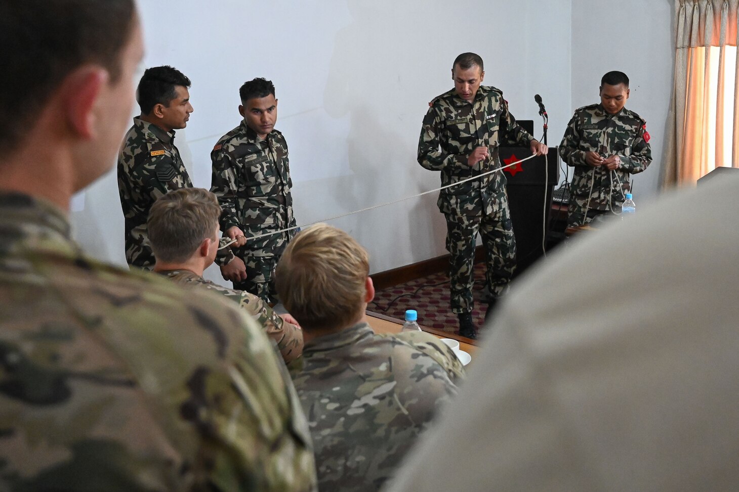 Nepali Army and Nepali Special Operations Force (SOF) Brigade members discuss various mountain climbing techniques with U.S. Naval Special Warfare operators during a subject matter expert exchange at Ganesh Kashya, the Nepali Army headquarters in Kathmandu, Nepal. Naval Special Warfare trains with forces worldwide to improve and further specialize skills required to conduct missions and respond to crises.