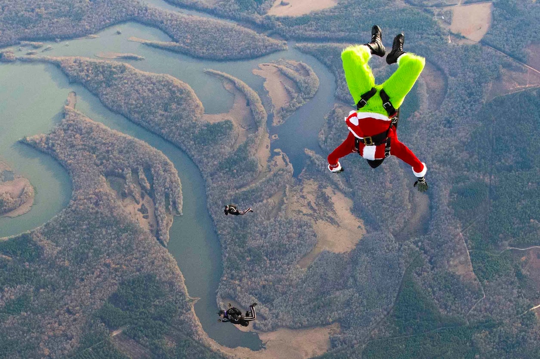 Three soldiers descend in the sky while one wears a Grinch costume.