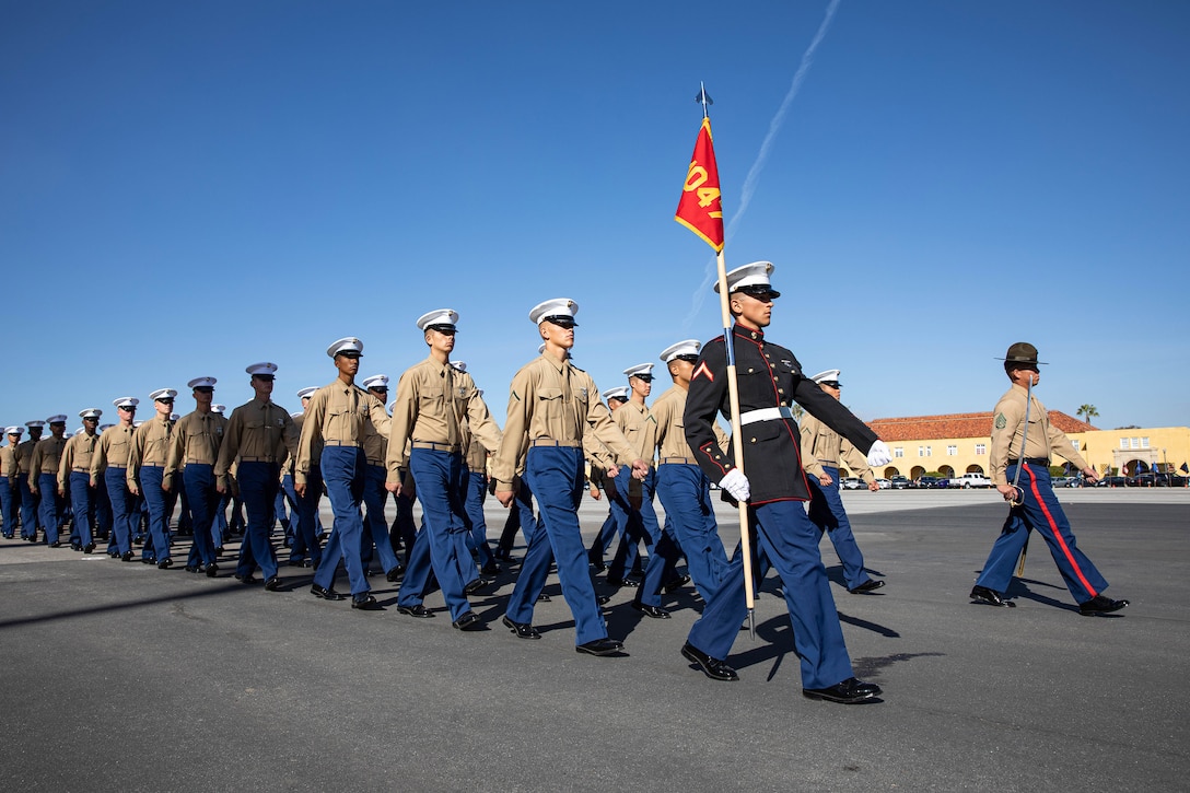 Marines march in formation during a graduation ceremony.