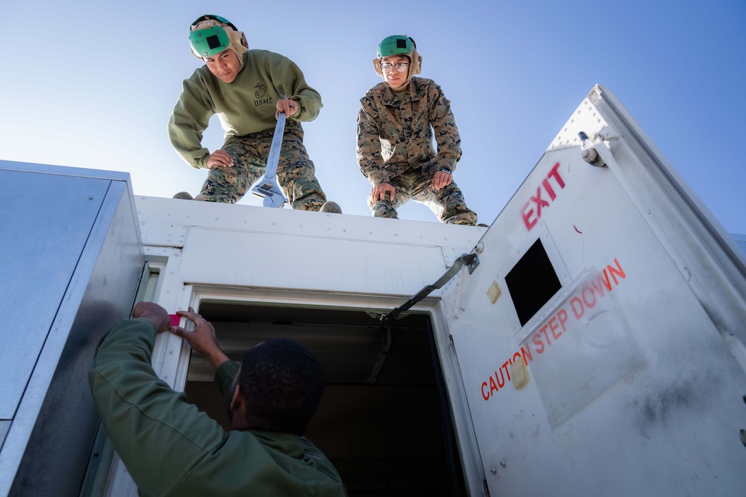 Three Marines set up a mobile facility.