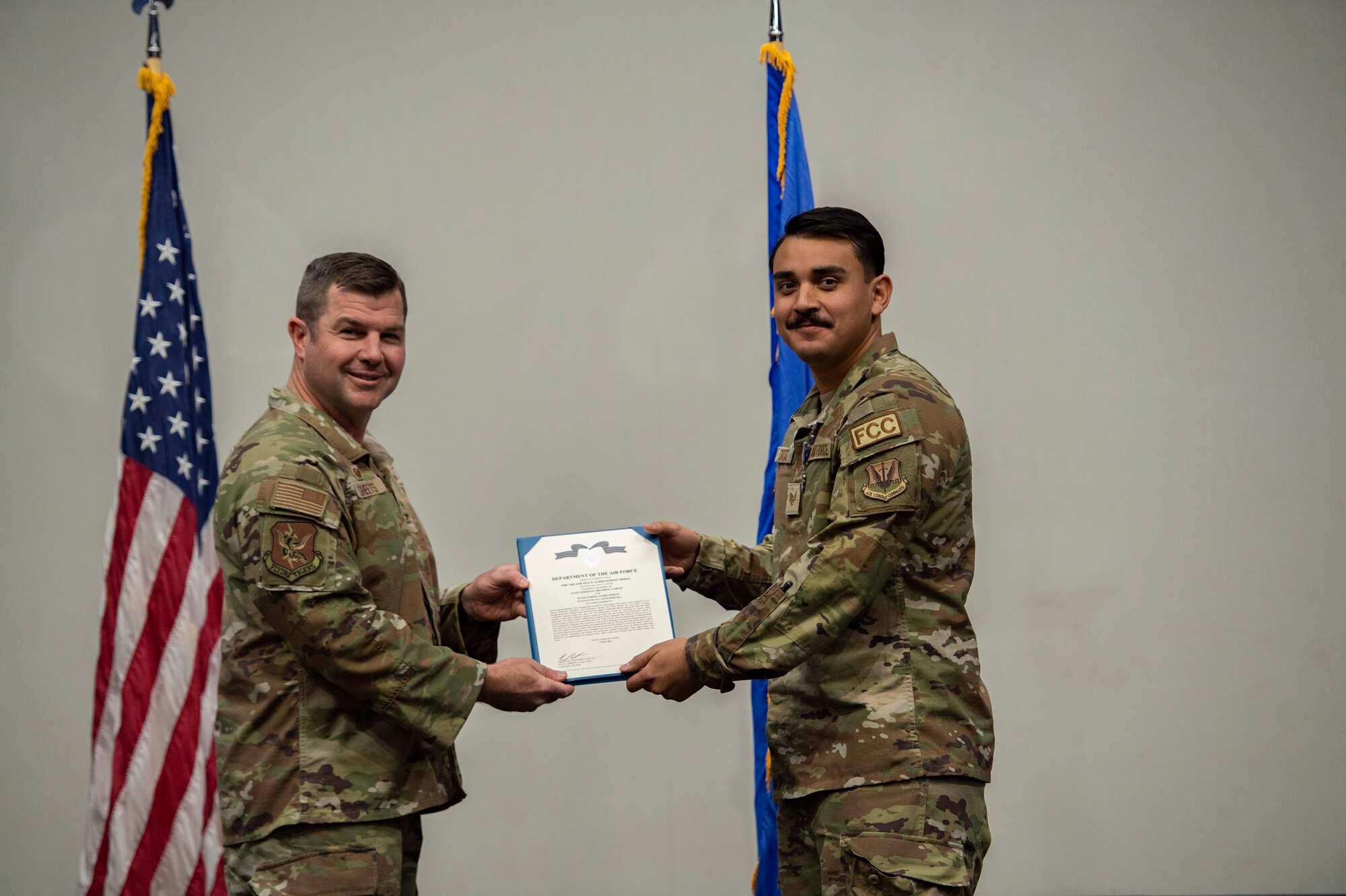 Base commander poses for photo with award recipient