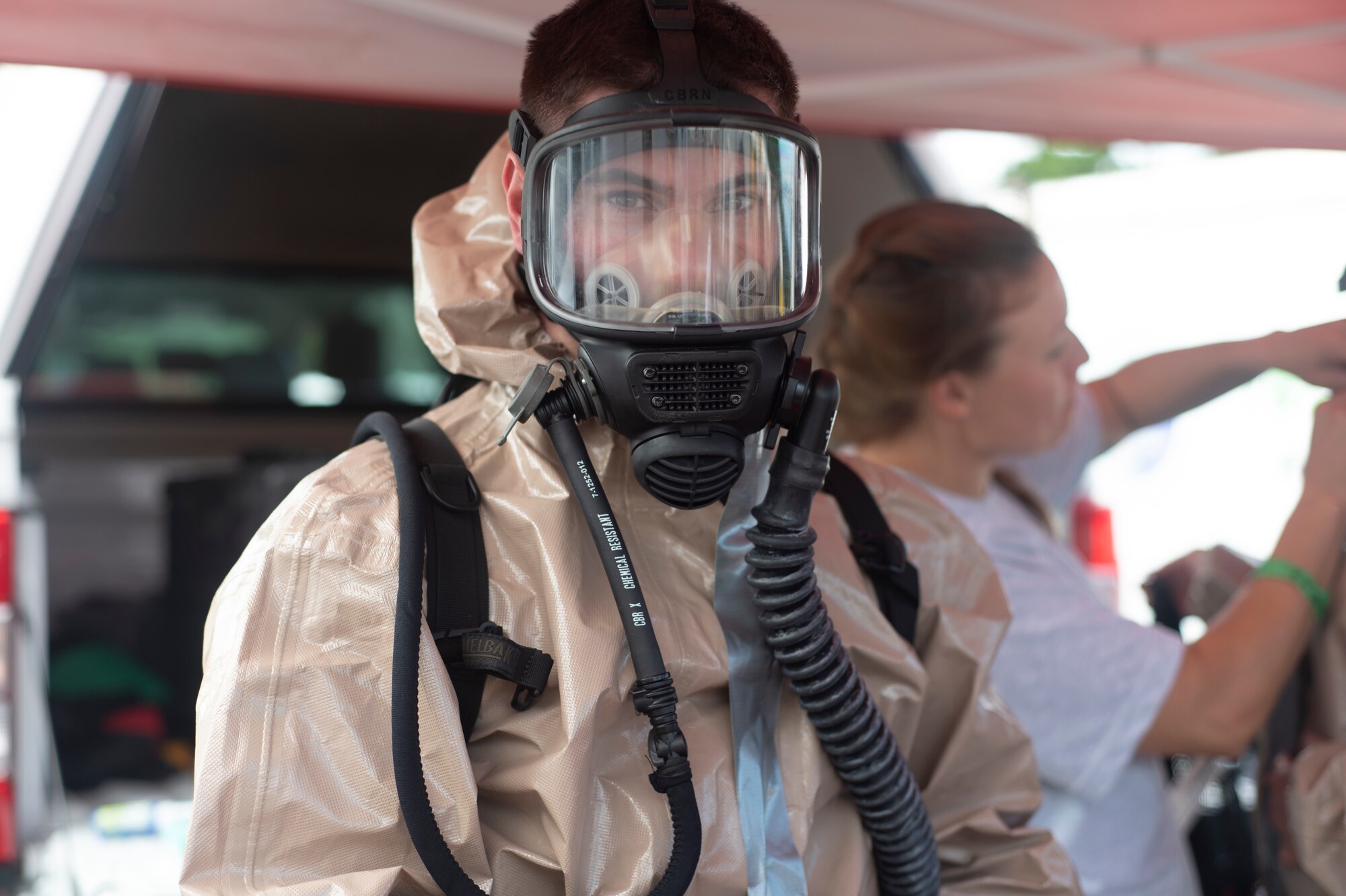 Airmen gets dressed in chemical protective gear.