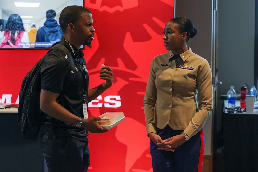 AURORA, Colo. — U.S. Marine Corps Maj. Alicia Chambers, expeditionary communications officer, Expeditionary Strike Group 2, right, talks with Joshua Fulton, assistant track and field coach with Barton Community College at the United States Track & Field and Cross Country Coaches Association Convention in Aurora on Dec. 12, 2023. The Marines attending this event engaged with coaches to increase awareness of the Marine Corps and establish a partnership in the track & field and cross-country community. (U.S. Marine Corps photo by Lance Cpl. Brenna Ritchie)