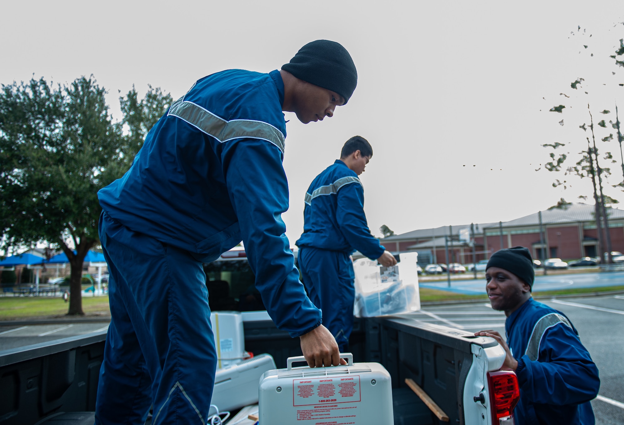 U.S. Air Force Airmen from Moody Air Force Base working for the Bay Orderly program, unload a truck at Moody Air Force Base, Georgia, Dec. 14, 2023. The Airmen regularly inspect vacant dorms on base to make sure they are ready to house new Airmen. (U.S. Air Force photo by Airman Cade Ellis)