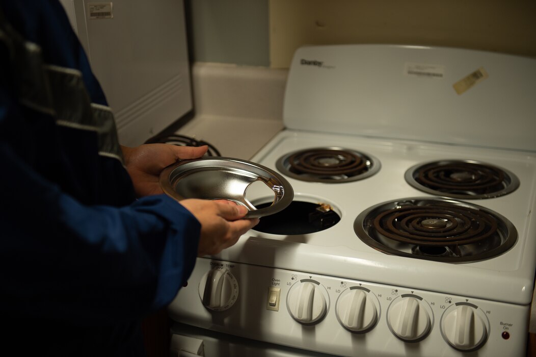 U.S. Air Force Airman 1st Class Richard Carmona Duarte, 23rd Healthcare Operations Squadron aerospace medical technician, inspects and maintains a kitchen stovetop at Moody Air Force Base, Georgia, Dec. 14, 2023. Duarte replaced one of the drip plates on the stove in one of the vacant dorms. An important part of the Bay Orderly program is making sure the dorms are kept in good condition. (U.S. Air Force photo by Airman Cade Ellis)