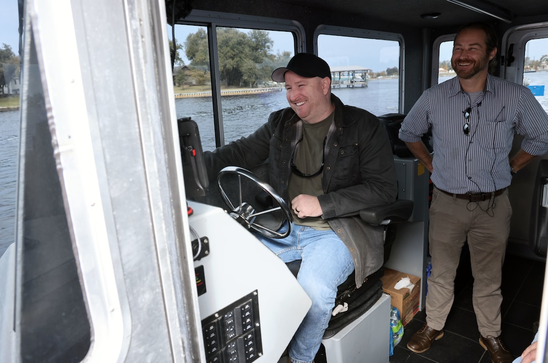 Jerry McLendon, U.S. Army Corps of Engineers, Mobile District Panama City Office Civil Engineering technician, seated, and Waylon Register, Panama City Office site manager, stand aboard the Survey Vessel St. Andrew, in Panama City, Florida, Dec. 8, 2023. The site office is responsible for the Navigation operations and maintenance and the dredging and disposal area maintenance missions. (U.S. Army photo by Chuck Walker)