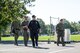 Service members from 55th Explosive Ordinance Disposal (EOD) Company and EOD agents from the FBI’s Washington Field Office a walking around a parking lot. They are dressed in dark green pants and shirts, and one member is in dark blue.