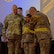 A group of U.S. Army soldiers stand on a stage