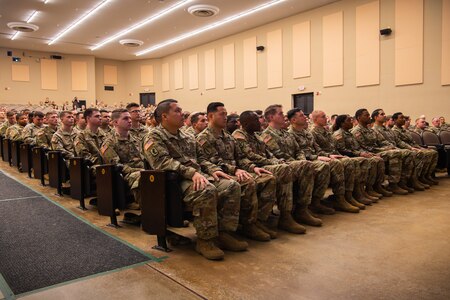 A group of U.S. Army soldiers sit in chairs during a ceremony