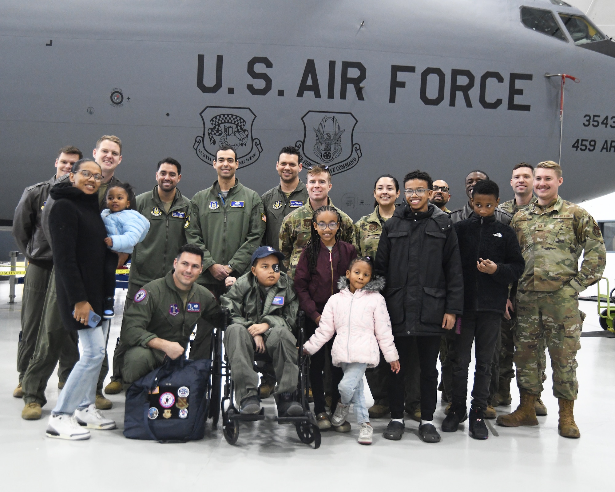 "Pilot for a Day," Jeremiah Hawkins, is surrounded by his family and members of the 459th ARW to pose for a group photo after getting a tour of the Air Force's KC-135 Stratotanker aircraft. The stop at the 459th was part of a base tour arranged by a local non-profit foundation that organizes and funds "Pilot for a Day" events for children with serious medical conditions. (Air Force Photo by Lt. Col. Timothy Smith)