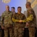 Group of U.S. Army soldiers stand on a stage during a ceremony
