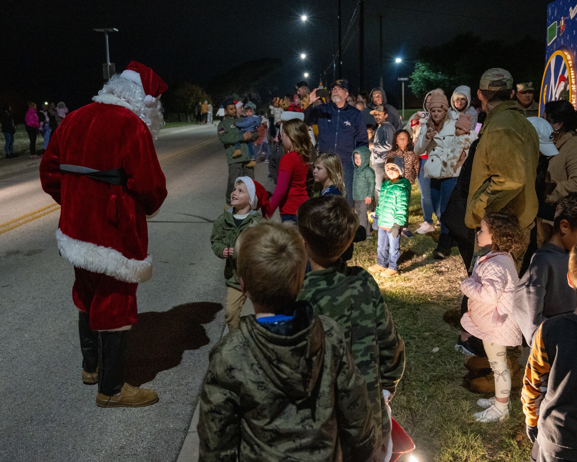 Santa greets children at the tree lighting ceremony at Laughlin Air Force Base, Texas, Nov. 29, 2023. After the ceremony children and their families were able to go and have "Dinner with Santa" at Club XL. (U.S. Air Force photo by Staff Sgt. Nicholas Larsen)