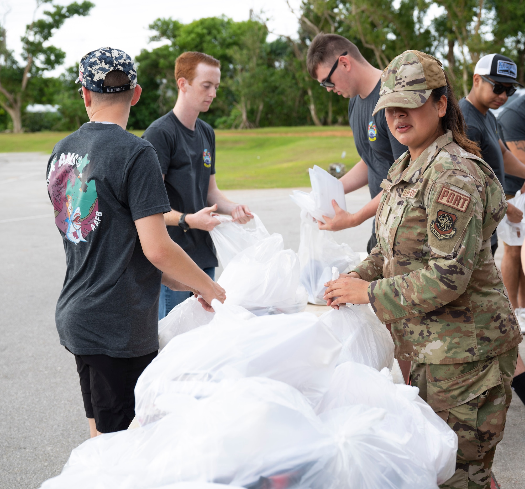 U.S. Air Force members assigned to the 734th Air Mobility Squadron, bag food during a volunteer event in Dededo, Guam, December 15, 2023. The 734 AMS volunteered to help Dededo as part of the Sister Village Sister Squadron program. They collected food, toiletry, and lifesaving equipment donations and helped hand them out to local families. (U.S. Air Force photo by Airman 1st Class Spencer Perkins)