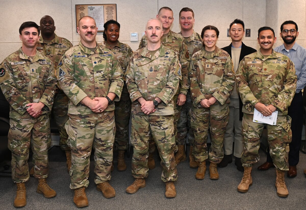 U.S. Space Force Lt. Col. Joshua McCullion, U.S. Space Forces Korea commander, center left, and Master Sgt. Shawn Stafford, USSPACEFOR-KOR senior enlisted leader, and other members of SPACEFOR-KOR, pose for a photo with the Space Systems Command Galaxy X cohort during their visit to Osan Air Base, Republic of Korea, November 30, 2023.