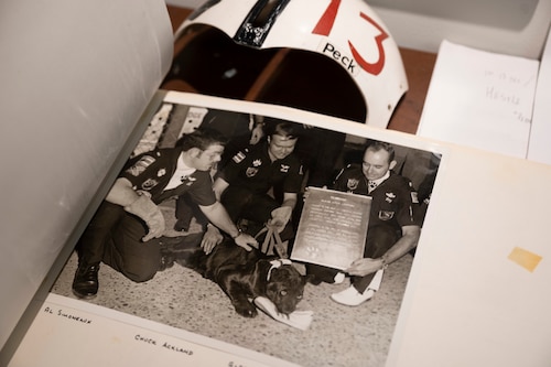 Officers with the 13th Fighter Squadron hold on to a panther biting into a shoe.