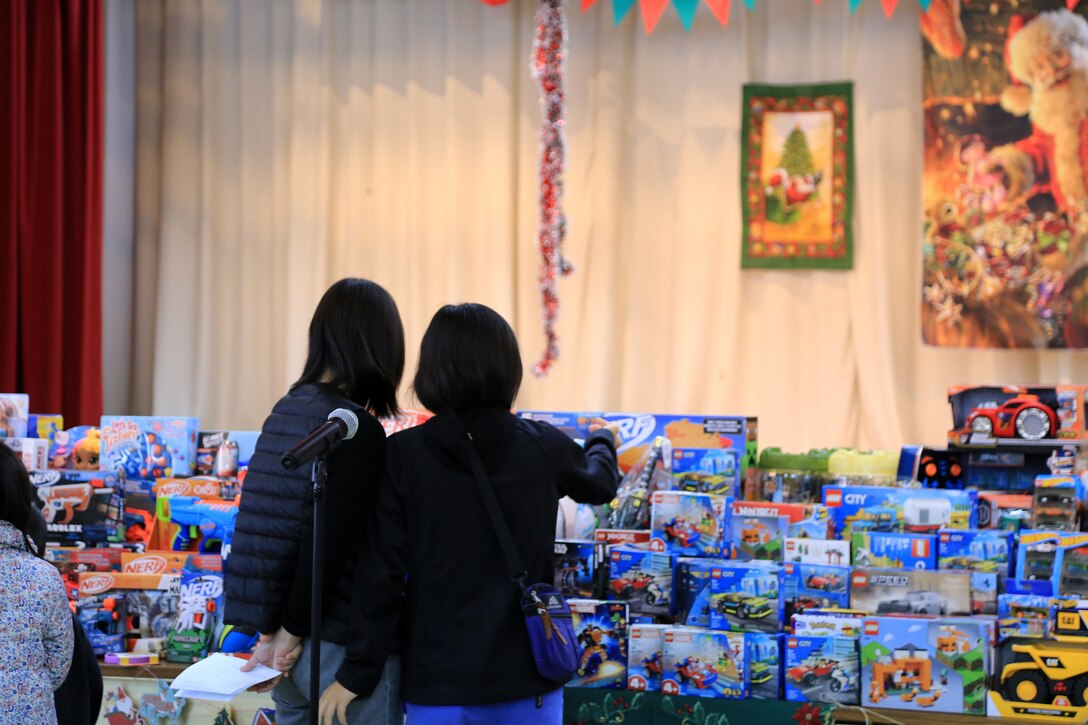 １２月１７日、宜野湾市社会福祉センターで第１９回宜野湾市母子寡婦福祉会主催のクリスマス会が開催されました。
そこで配られたおもちゃは米国防省教育部（DoDEA）クバサキ高校のJROTC（高校生に向けた予備役将校訓練課程）に所属するカデッツ（士官の候補生）たちが放課後や週末に海兵隊基地内のショッピングセンターで空箱の横に立ち、買い物客におもちゃの寄贈を促す「トイズ・フロム・カデッツ」で集められたものです。