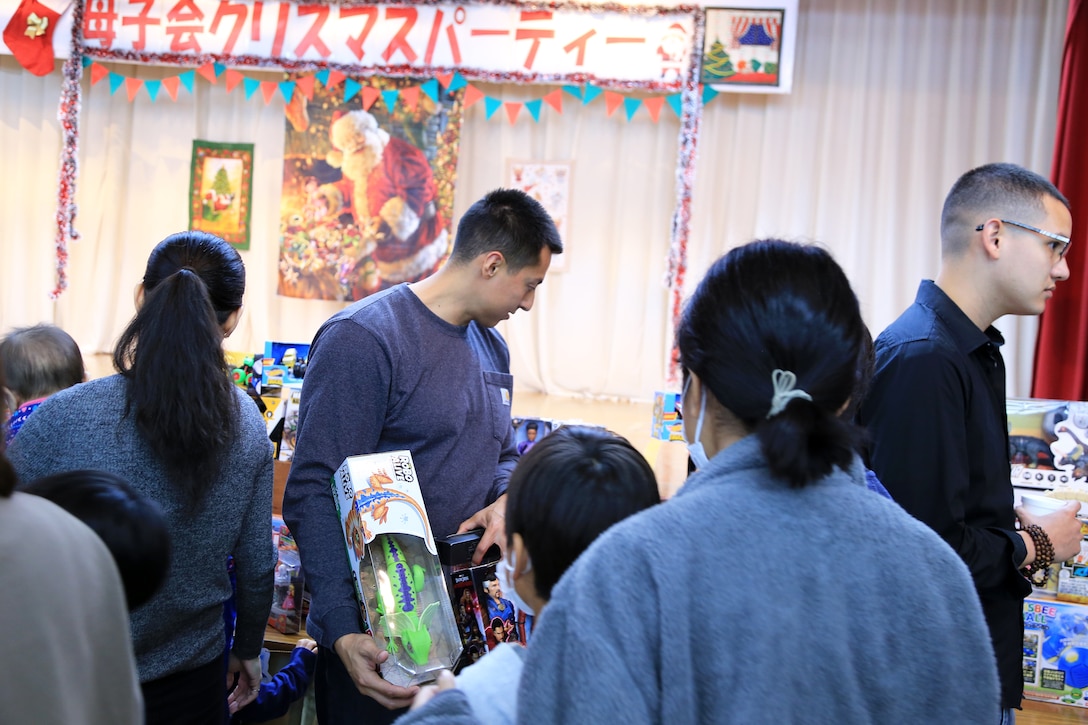 １２月１７日、宜野湾市社会福祉センターで第１９回宜野湾市母子寡婦福祉会主催のクリスマス会が開催されました。
そこで配られたおもちゃは米国防省教育部（DoDEA）クバサキ高校のJROTC（高校生に向けた予備役将校訓練課程）に所属するカデッツ（士官の候補生）たちが放課後や週末に海兵隊基地内のショッピングセンターで空箱の横に立ち、買い物客におもちゃの寄贈を促す「トイズ・フロム・カデッツ」で集められたものです。