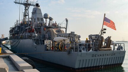 MANAMA, Bahrain (Dec. 17, 2023) Personnel aboard the U.S. Navy Avenger-class mine countermeasures ship USS Devastator (MCM 6) make preparations to depart Naval Support Activity (NSA) Bahrain for sea trials, Dec. 17. NSA Bahrain enables the forward operations and responsiveness of U.S. and allied forces in support of Navy Region Europe, Africa, Southwest Asia's mission to provide services to the fleet, warfighter and family. (U.S. Navy photo by Mass Communication Specialist 2nd Class MacAdam Kane Weissman)