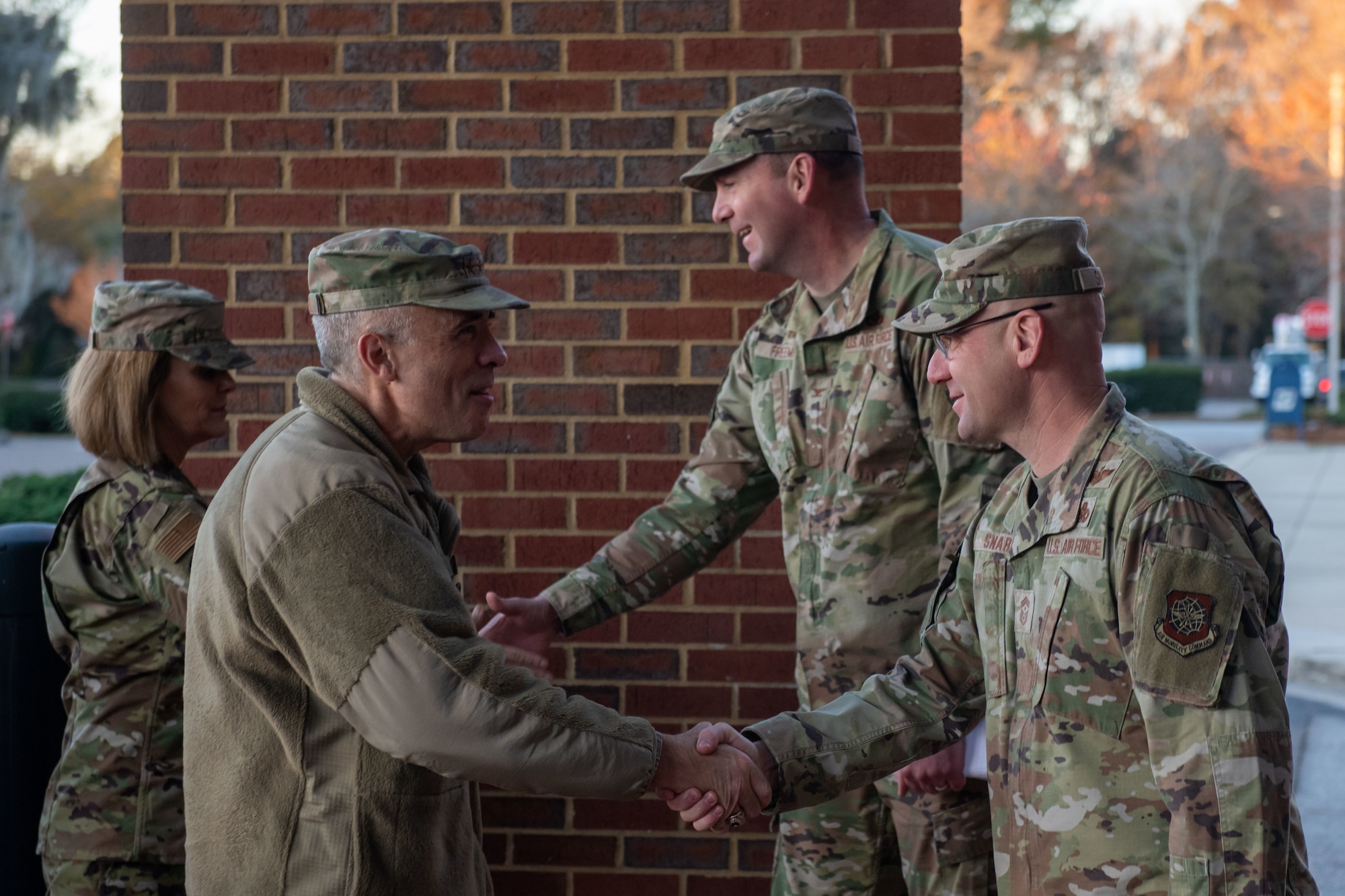 A photo of four people shaking hands.