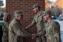 A photo of four people shaking hands.
