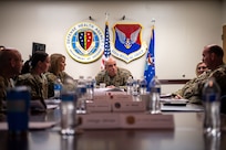 A photo of many people talking at a table.