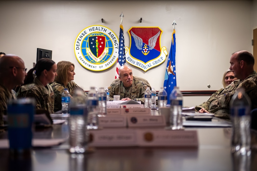 A photo of many people talking at a table.