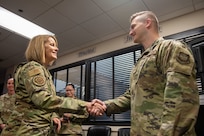 A photo of an Airman receiving a coin.