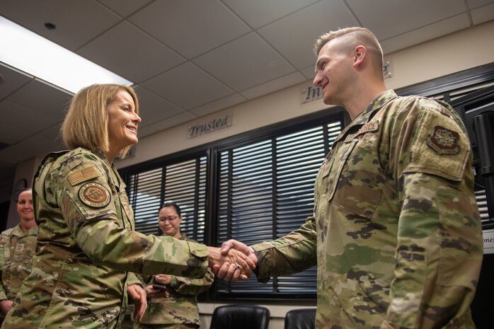 A photo of an Airman receiving a coin.