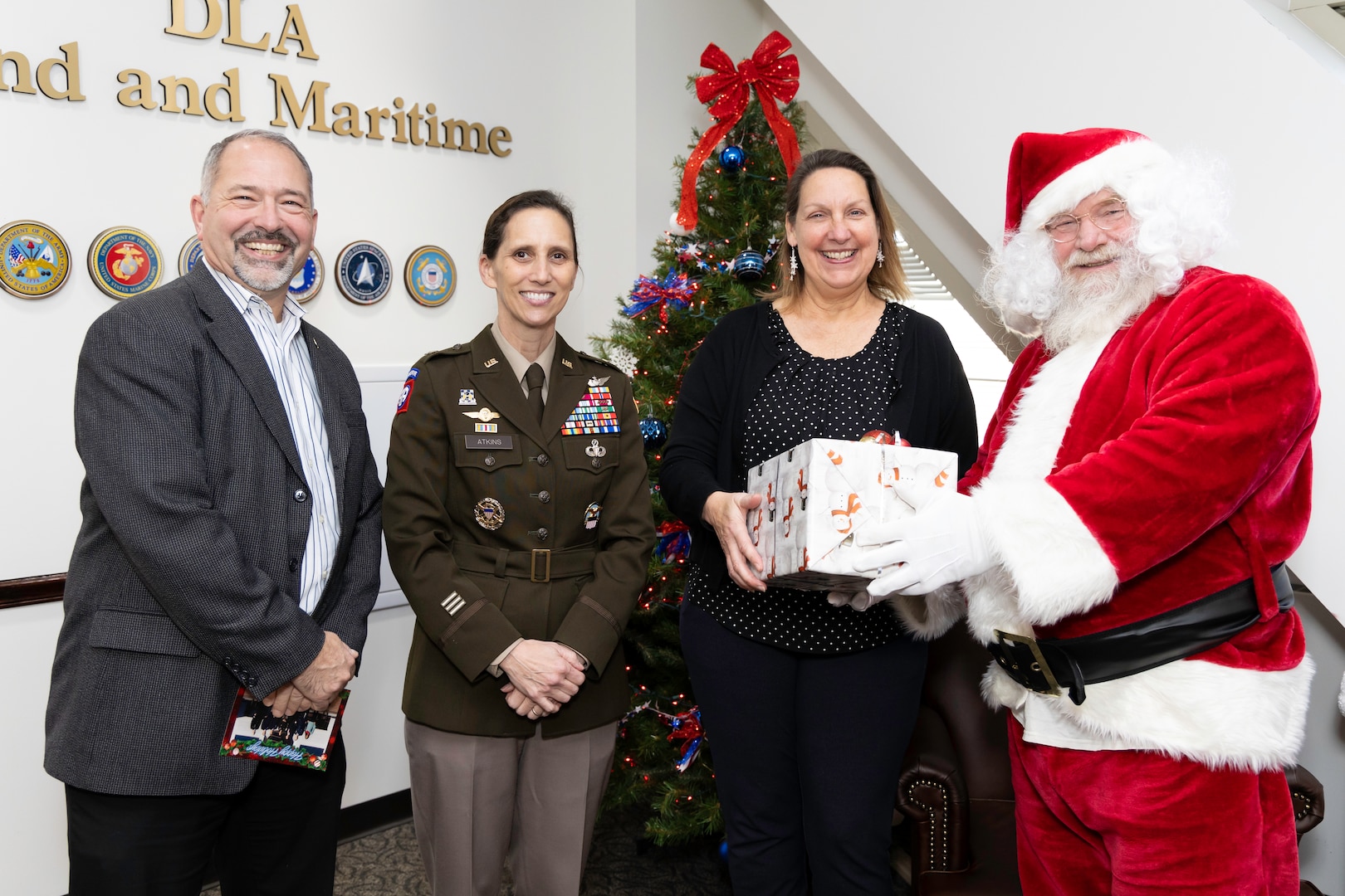 Man and two women pose with Santa.