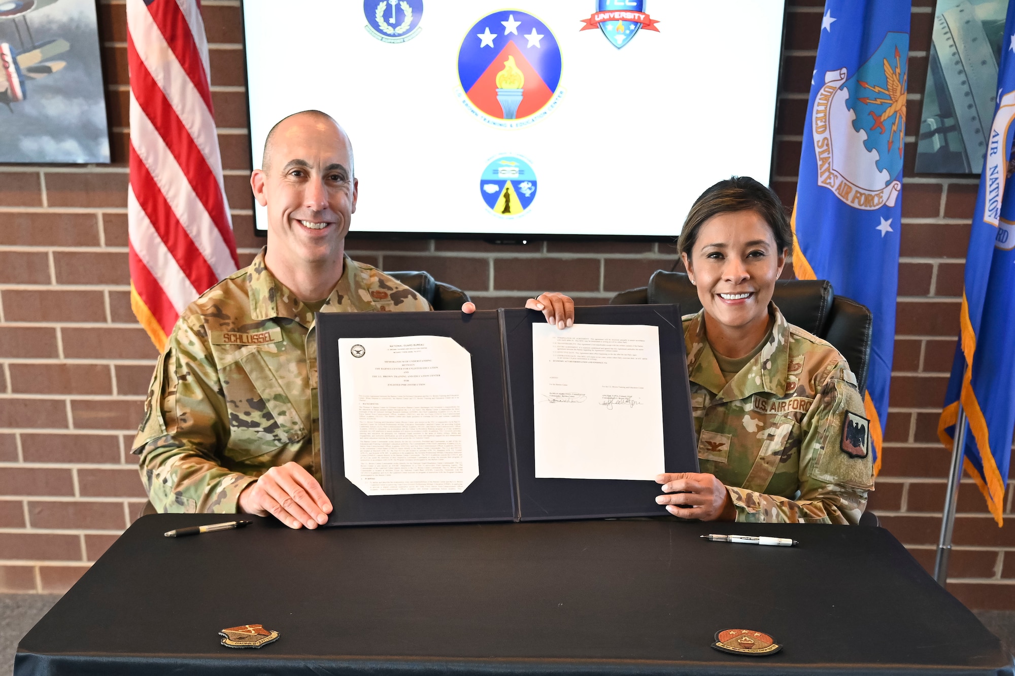 U.S. Air Force Col. Angela Tapia, commander, I.G. Brown Training and Education Center (TEC), and U.S. Air Force Col. Damian Schlussel, commander, Barnes Center for Enlisted Professional Military Education (EPME), sign a memorandum of understanding (MOU), McGhee Tyson Air National Guard Base, Tennessee, Dec. 14, 2023.  The signing of the MOU solidified the collaborative relationship between the TEC and the Barnes Center for EPME for educating and developing Total Force enlisted leaders. (photo by Master Sgt. Regina Young)