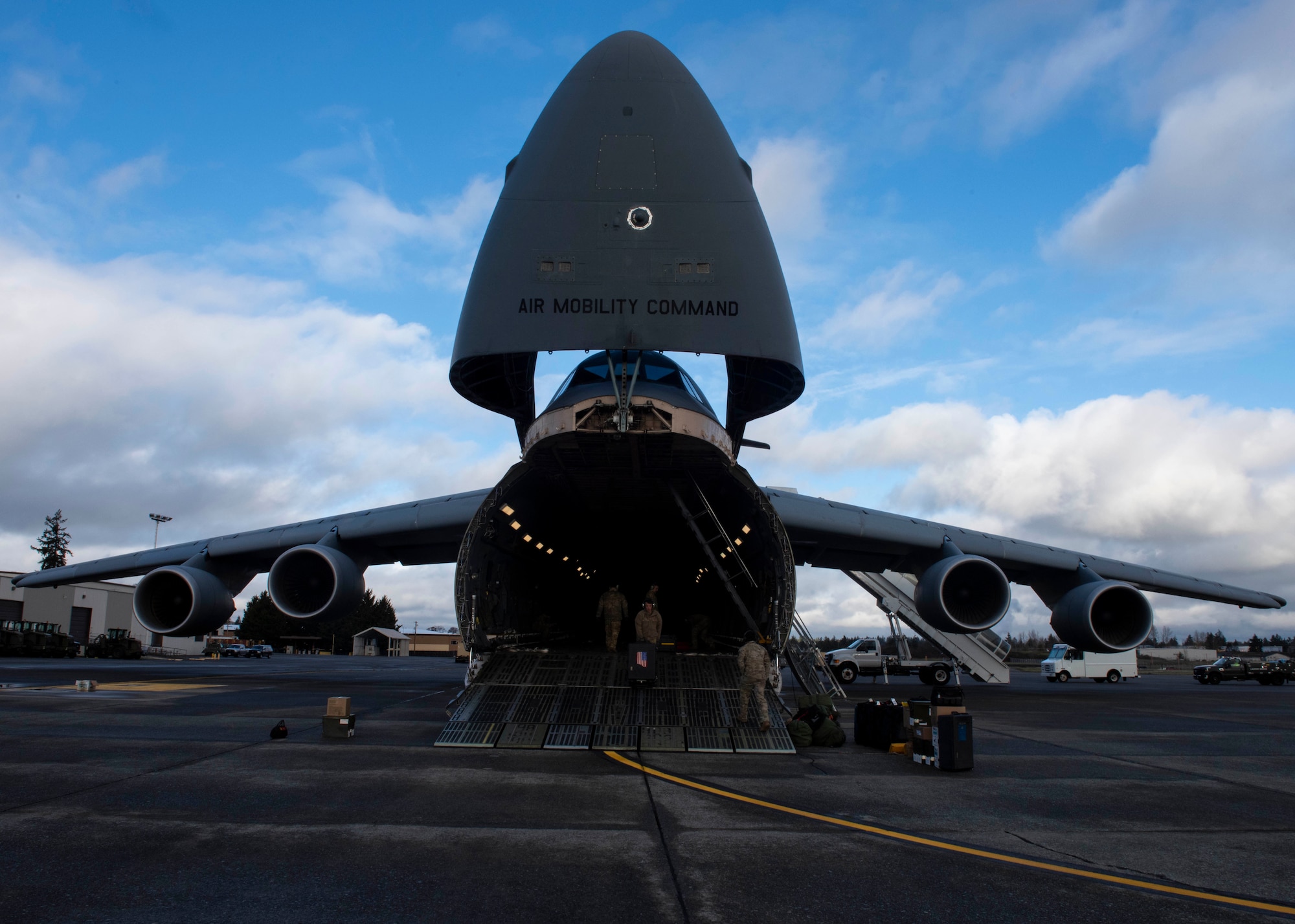 U.S. Air Force Airmen and Navy Sailors prepare to load vehicles onto a C-5M Super Galaxy at Joint Base Lewis-McChord, Wash., Dec. 8, 2023. The C-5M Super Galaxy is one of the largest military aircrafts providing joint airlift capability ensuring readiness in executing today’s global airlift mission and providing mission-ready aircrew and aircraft across the globe. (U.S. Air Force photo by Airman 1st Class Megan Geiger)