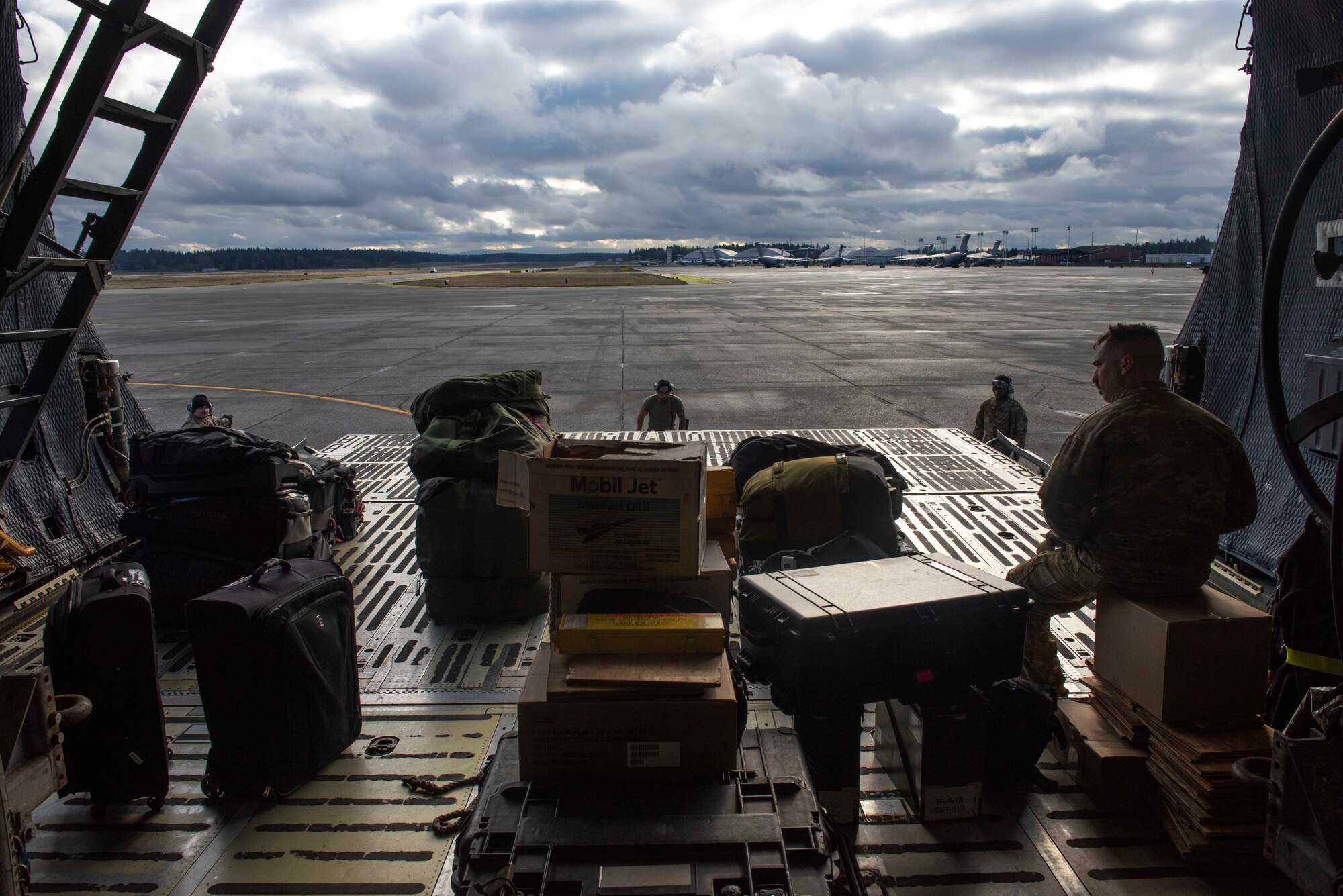 U.S. Air Force Airmen and Navy Sailors load cargo inside a C-5M Super Galaxy at Joint Base Lewis-McChord, Wash., Dec. 8, 2023. The joint operation consisted of loading cargo and mini submersibles on the aircraft and was conducted by service members from Travis Air Force Base, Calif., Joint Base Pearl Harbor-Hickam, Hawaii, and JBLM. (U.S. Air Force photo by Airman 1st Class Megan Geiger)