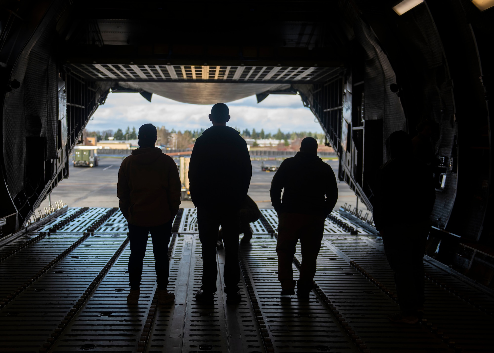 U.S. Air Force Airmen and Navy Sailors load cargo onto a C-5M Super Galaxy at Joint Base Lewis-McChord, Wash., Dec. 8, 2023. The joint operation consisted of loading cargo and mini submersibles on the aircraft and was conducted by service members from Travis Air Force Base, Calif., Joint Base Pearl Harbor-Hickam, Hawaii, and JBLM. (U.S. Air Force photo by Airman 1st Class Megan Geiger)