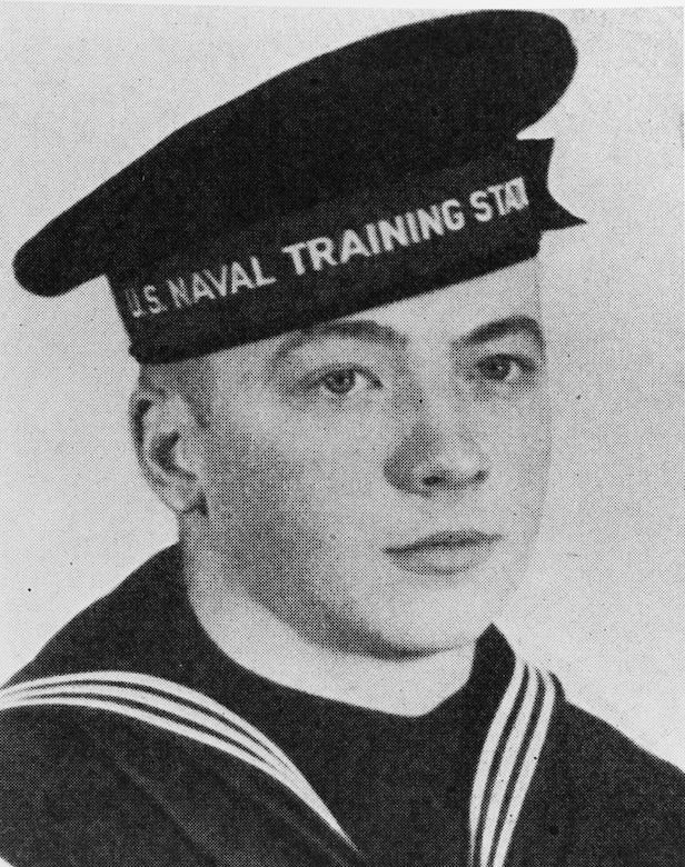A person in a sailor’s cap poses for a photo.